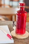 Red Syrup In The Bottle On Wooden Plate Stock Photo