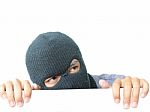 Robber Hiding Under A White Wall Stock Photo