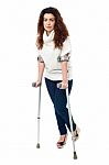 Sad Faced Woman Limping With Crutches Stock Photo