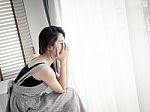 Sad Woman Sitting Alone In Room Stock Photo