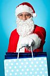 Santa Holding Shopping Bags In His Outstretched Arms Stock Photo