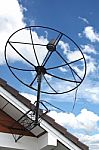 Satellite Dish Stuck To Roof Of House In Blue Sky Stock Photo