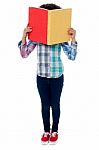 School Girl Hiding Her Face With A Book Stock Photo