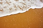 Sea Wave With Foam On Sand Stock Photo