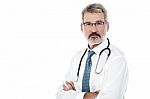 Senior Male Doctor With Crossed Arms Stock Photo