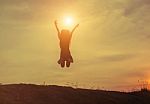 Silhouette Of Woman Jumping Against Beautiful Sky Background Stock Photo