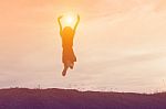 Silhouette Of Woman Jumping Against Beautiful Sky Background Stock Photo