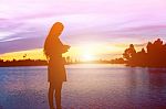 Silhouette Of Woman Praying Over Beautiful Sky Background Stock Photo