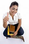 Sitting Girl Showing Thumbs Up Stock Photo