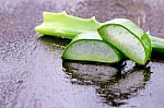Slice Aloe Vera On Wet Wood Background Stock Photo