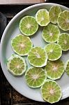 Slice Of Peeled Green Fresh Lime On White Plate Stock Photo