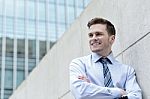 Smiling Businessman Standing Against Wall Stock Photo