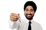 Smiling Corporate Guy Holding A House Key Stock Photo