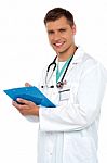 Smiling Doctor holding Clipboard Stock Photo