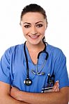 Smiling Female Doctor With Arms Crossed Stock Photo