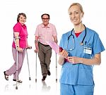 Smiling Female Physician With Aged Patients Stock Photo