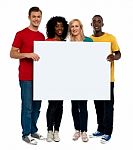 Smiling friends holding blank board Stock Photo