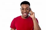 Smiling Guy Attending A Phone Call Stock Photo