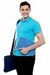 Smiling Guy Holding Notepad And Laptop Bag Stock Photo