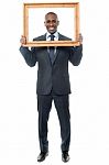Smiling Guy Looking Through Picture Frame Stock Photo