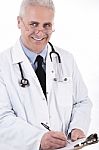 Smiling Medical Doctor Writing Prescription Stock Photo
