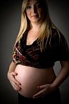 Smiling Pregnant Female Holding Her Tummy Stock Photo