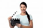 Smiling Woman Holding A Movie Slate In Hand Stock Photo