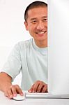 Smiling Young Asian Man Using Computer Stock Photo