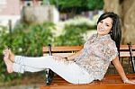 Smiling Young Girl Sitting In Park Stock Photo