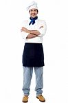 Smiling Young Male Chef With Arms Crossed Stock Photo
