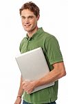 Smiling Young Man Holding Laptop Stock Photo