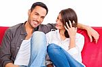 Smiling Young Man With Girlfriend On Sofa Stock Photo