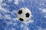 Soccer Ball In Goal Net With Blue Sky Stock Photo