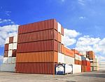 Stacked Cargo Containers In Storage Area With Blue Sky Stock Photo