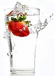 Strawberry Dropping Into Glass Stock Photo