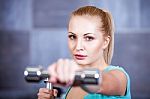 Strong Blonde Woman Weightlifting At The Gym Stock Photo