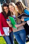 Students Having Fun With Smartphones After Class Stock Photo