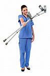 Sullen Faced Doctor Displaying Crutches Stock Photo