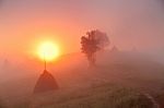 Sunrise Over Mountain Field. Haystacks In Misty Autumn Morning H Stock Photo