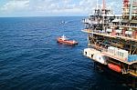 Supply Boat Transfer Cargo To Oil And Gas Industry And Moving Cargo From The Boat To The Platform Stock Photo