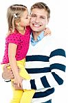 Sweet Daughter Kissing Her Smiling Father Stock Photo