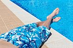 Teenage Boy Sunbathing At Swimming Pool Stock Photo