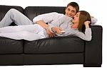 Teenage Couple Lying On Sofa Stock Photo