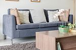Three Of Pillows On Dark Blue Sofa In Modern Living Room Stock Photo