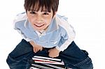 Top Angle Image Of Kid Sitting On Books Stock Photo