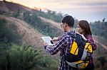 Tourists Look At A Map On The Tablet On Mountain Stock Photo