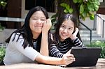 Two Asia Thai High School Student Best Friends Beautiful Girl Using Her Tablet And Funny Stock Photo