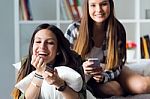 Two Beautiful Young Woman Staying On Sofa At Home Stock Photo