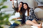 Two Beautiful Young Woman Using Mobile Phone At Home Stock Photo