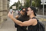 Two Cheerful Friends Taking Photos Of Themselves On Smart Phone Stock Photo